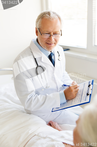 Image of senior woman and doctor with clipboard at hospital