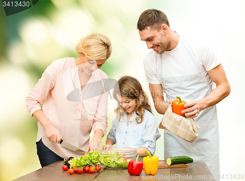 Image of happy family cooking vegetable salad for dinner