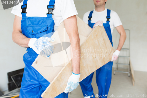 Image of close up of builders carrying wooden boards