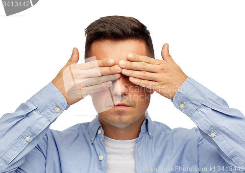 Image of face of man covering his eyes with hands