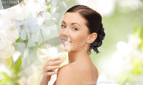 Image of woman with soap bar over cherry blossom background