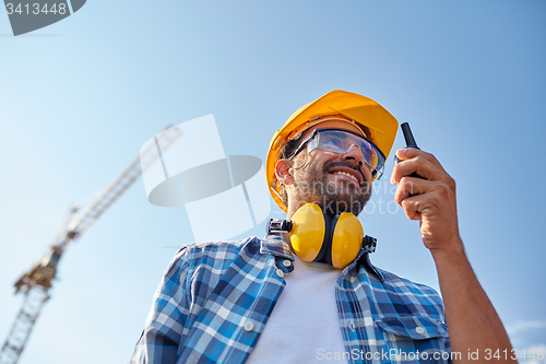 Image of builder in hardhat with walkie talkie