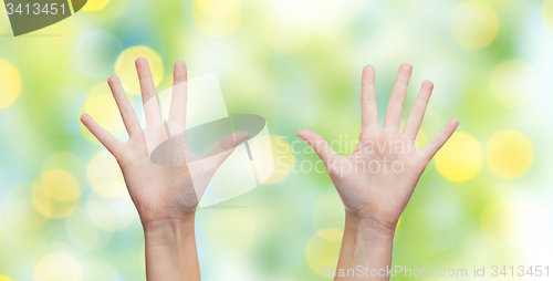 Image of two woman hands making high five over blue sky