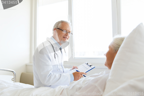 Image of senior woman and doctor with clipboard at hospital