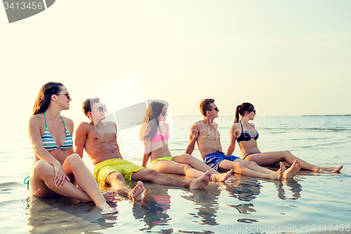 Image of smiling friends in sunglasses on summer beach