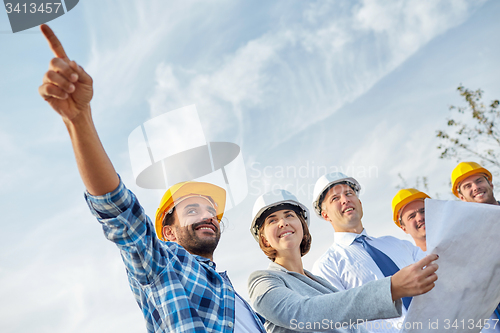 Image of group of builders and architects with blueprint