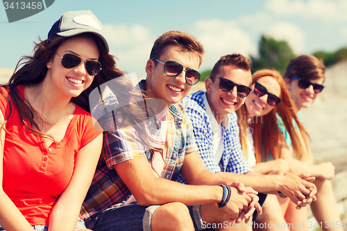 Image of close up of smiling friends sitting on city street