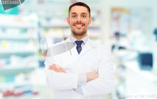 Image of smiling male pharmacist in white coat at drugstore