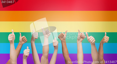Image of hands showing thumbs up over rainbow background