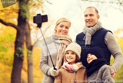 Image of happy family with smartphone and monopod in park