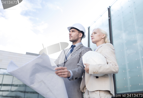 Image of businessmen with blueprint and helmets