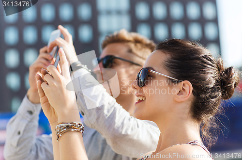 Image of smiling friends with smartphone taking picture