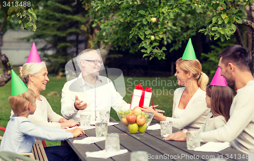 Image of happy family having holiday dinner outdoors