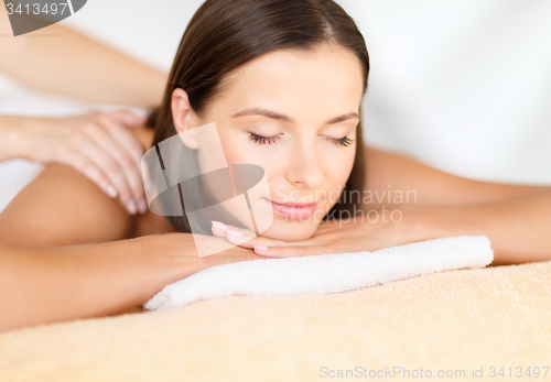 Image of beautiful woman in spa salon getting massage