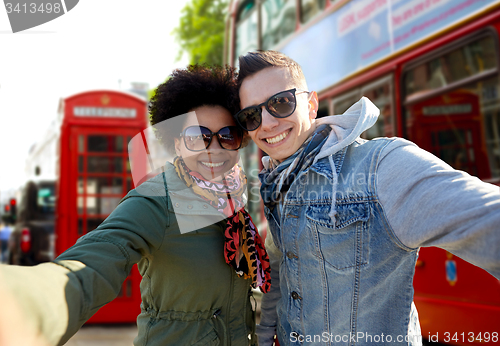 Image of happy teenage couple taking selfie in london city