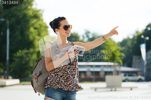 Image of happy teenage girl with guidebook and backpack