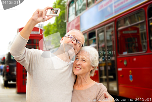 Image of senior couple photographing on london city street