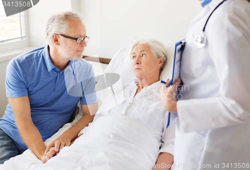 Image of senior woman and doctor with clipboard at hospital