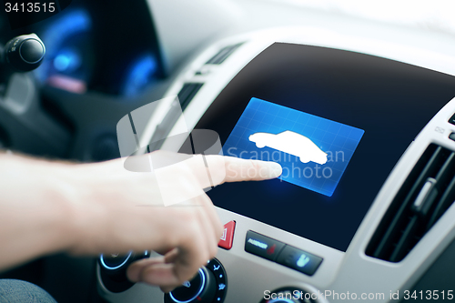 Image of male hand pointing finger to car icon on panel