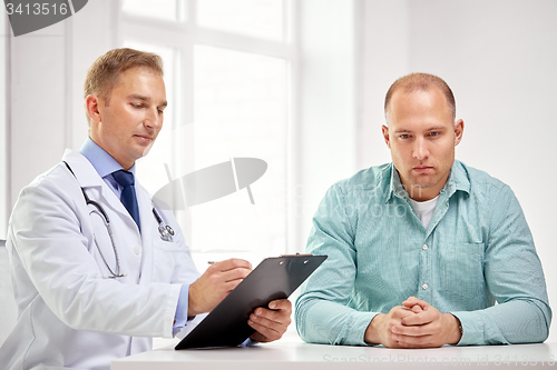 Image of male doctor and patient with clipboard at hospital