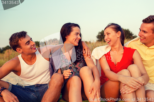 Image of smiling friends in sunglasses on summer beach