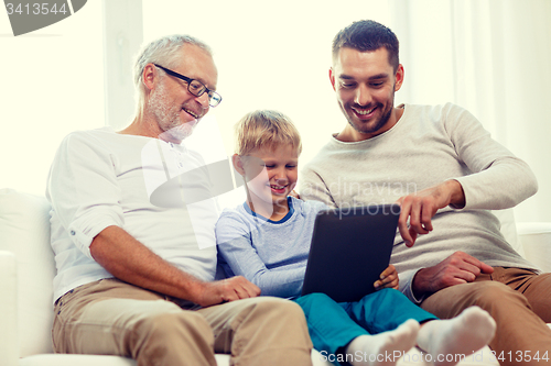 Image of smiling family with tablet pc at home