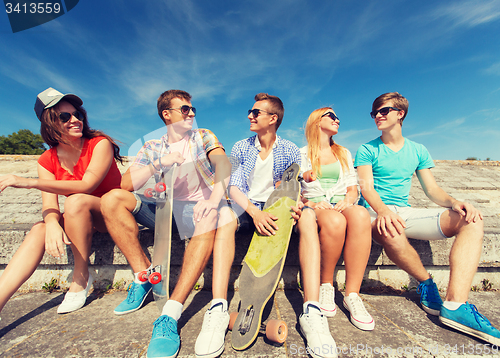 Image of group of smiling friends sitting on city street