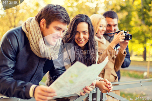 Image of group of friends with map and camera outdoors