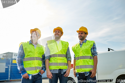 Image of happy male builders in high visible vests outdoors