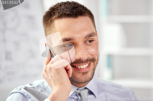 Image of young smiling businessman calling on smartphone