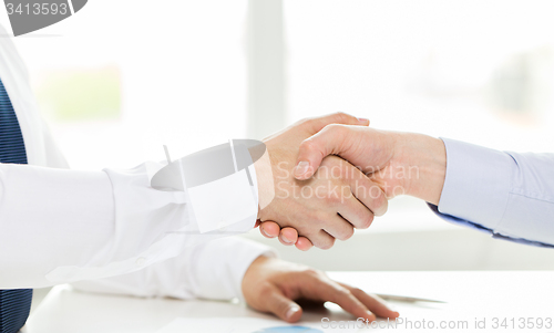 Image of close up of hands making handshake in office