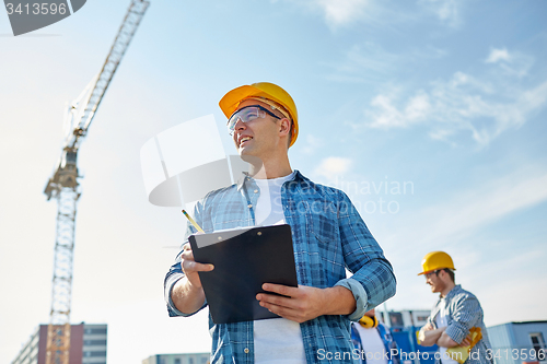 Image of builder in hardhat with clipboard at construction