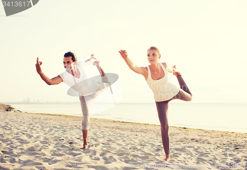 Image of couple making yoga exercises outdoors