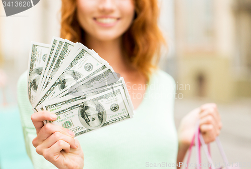 Image of close up of woman with shopping bags and money