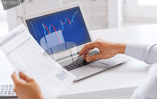 Image of businessman working with forex chart in office