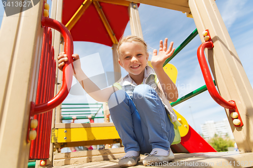 Image of happy little girl climbing on children playground