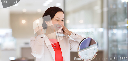 Image of happy woman choosing pendant at jewelry store