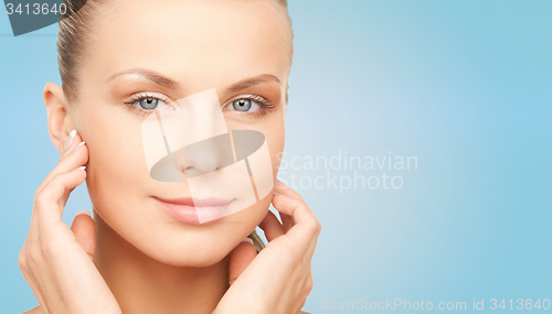 Image of beautiful young woman touching her face