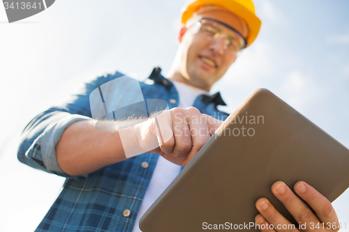 Image of close up of builder in hardhat with tablet pc
