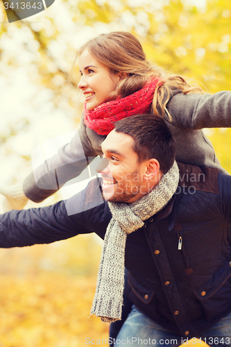 Image of smiling couple having fun in autumn park