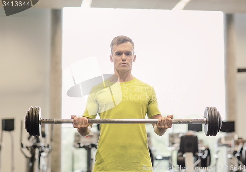 Image of man doing exercise with barbell in gym