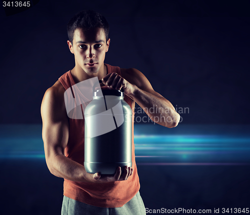 Image of young male bodybuilder holding jar with protein