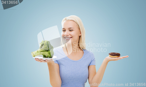 Image of smiling woman with broccoli and donut