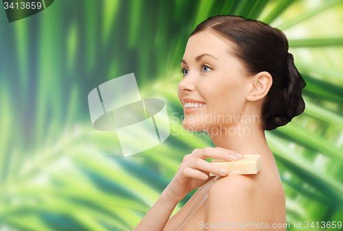 Image of woman with soap over green palm leaf background