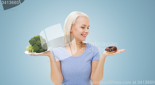 Image of smiling woman with broccoli and donut