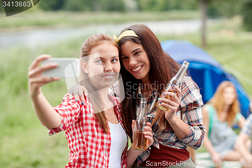 Image of happy women taking selfie by smartphone at camping