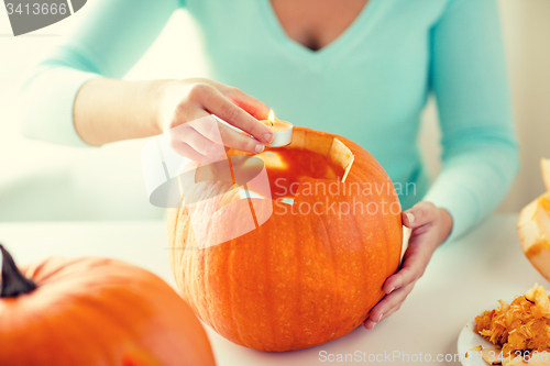 Image of close up of woman with pumpkins at home