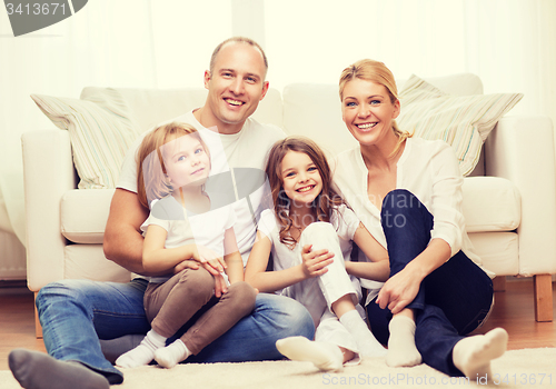 Image of parents and two girls sitting on floor at home