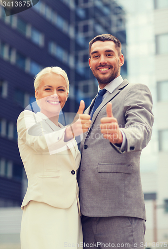 Image of smiling businessmen showing thumbs up