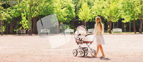 Image of happy mother with stroller in park